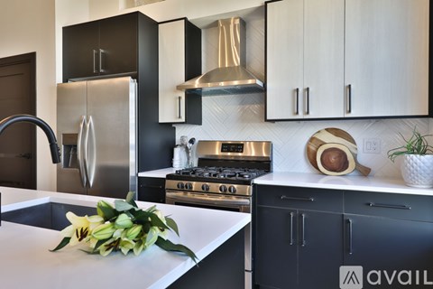 A modern kitchen with a stainless steel refrigerator and a white countertop.