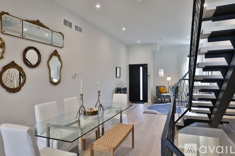 A modern dining room with a glass table and chairs.