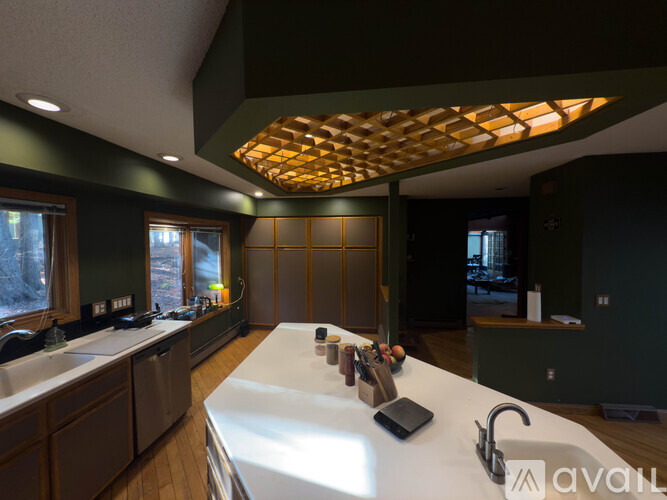 A kitchen with a long counter and a wooden ceiling.