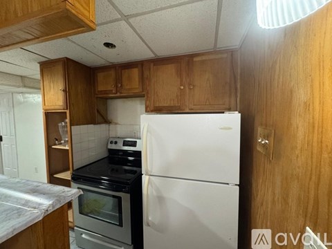 A kitchen with wooden cabinets and a white refrigerator.