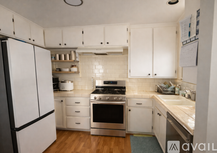 A kitchen with white cabinets and appliances.