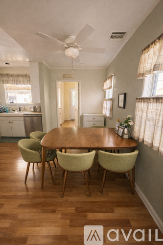 A dining room with a wooden table and chairs.