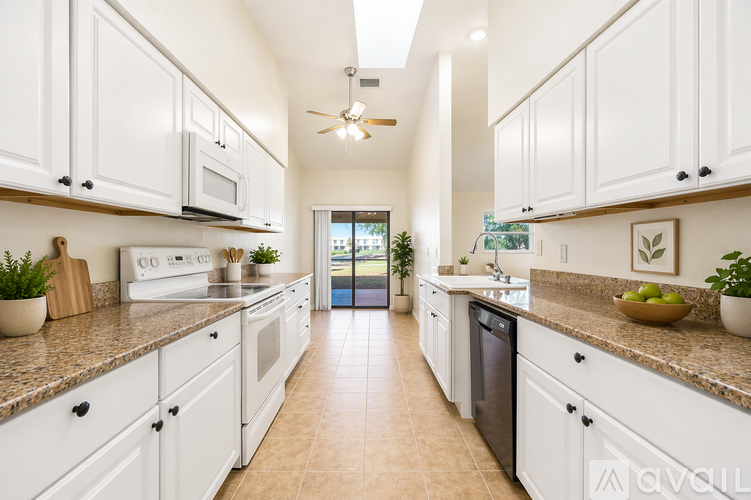 A kitchen with white cabinets and a tiled floor.