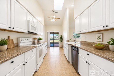 A kitchen with white cabinets and a tiled floor.