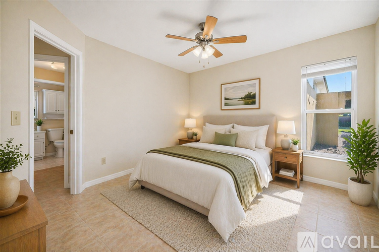 A bedroom with a large bed and a ceiling fan.