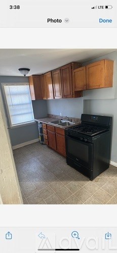 A kitchen with brown cabinets and a black stove top oven.