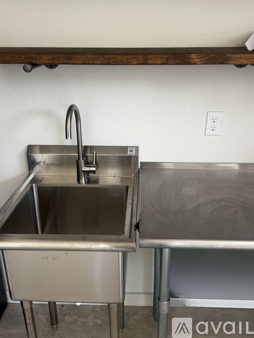 A stainless steel sink with a faucet is installed in a kitchen.