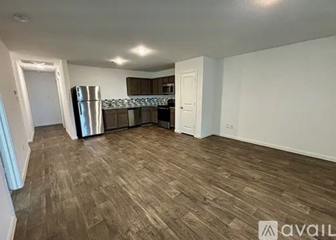 A kitchen area with a refrigerator, cabinets, and a countertop.