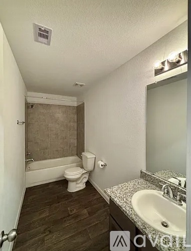 A bathroom with a toilet, sink, and bathtub.