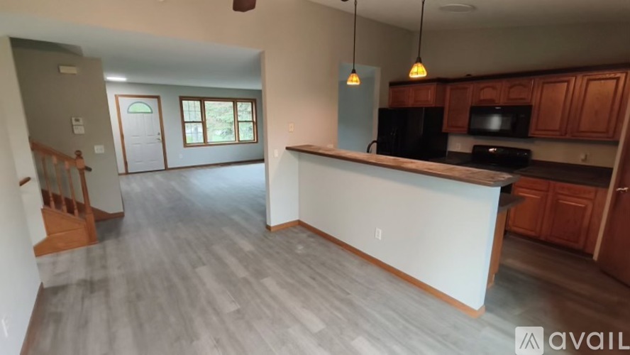 A kitchen with wooden cabinets and a black countertop.