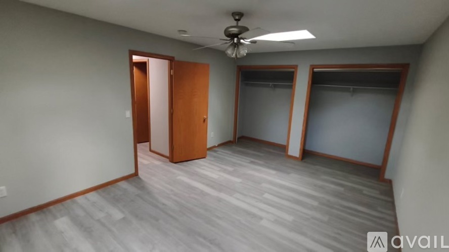 A room with a ceiling fan and two doors.