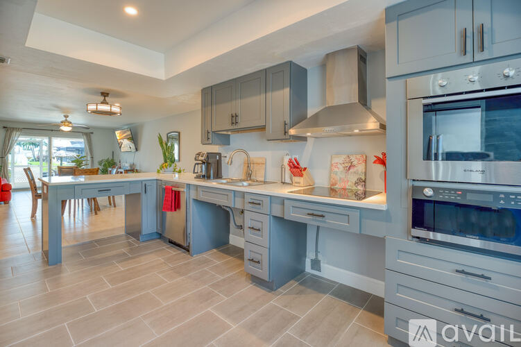 A modern kitchen with a large island and stainless steel appliances.