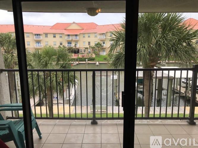 A balcony view of a resort with a pool and palm trees.