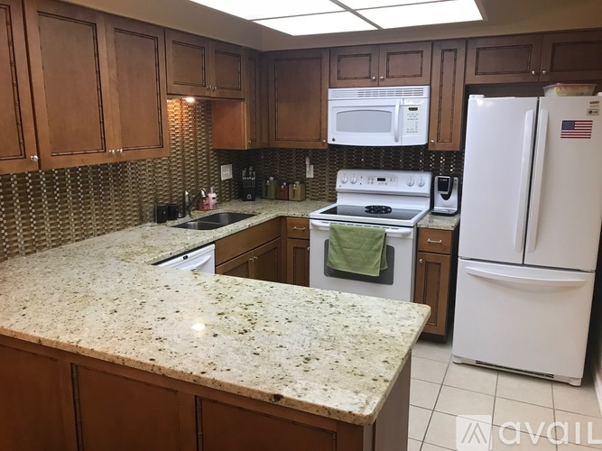 A kitchen with a granite counter top and white appliances.