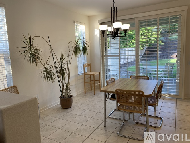 A dining room with a wooden table and chairs.