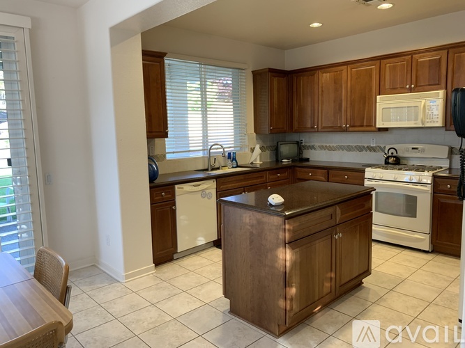 A kitchen with wooden cabinets and a white dishwasher.