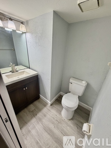 A white toilet sits in a bathroom next to a sink.