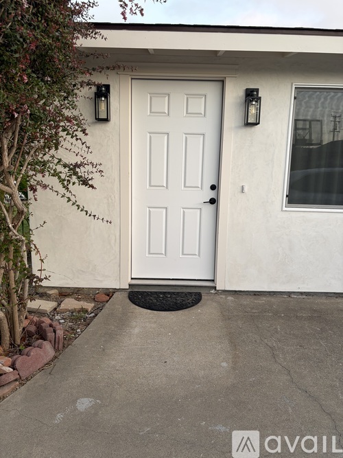 A white door with a black mat in front of it.