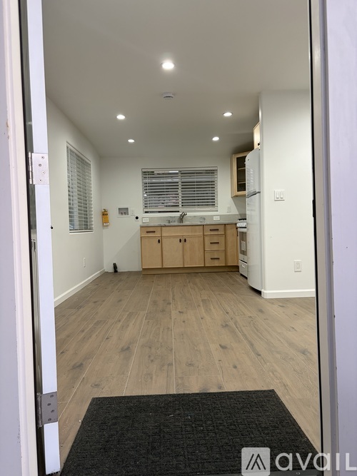 A kitchen with wooden floors and white walls.