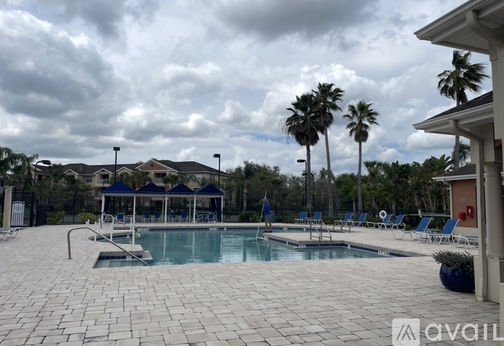 A pool area with a gazebo and palm trees in the background.