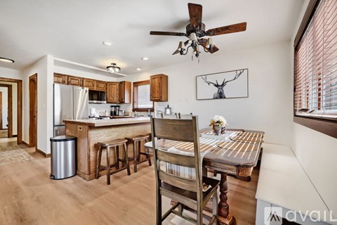 A kitchen with a bar area and a dining table with chairs.