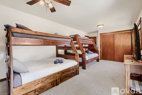A bedroom with a bunk bed and a television.