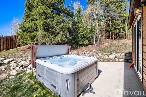 A hot tub is placed on a patio in a backyard.