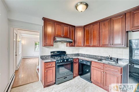 A kitchen with wooden cabinets and a black stove top oven.