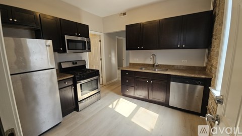A kitchen with black cabinets and stainless steel appliances.