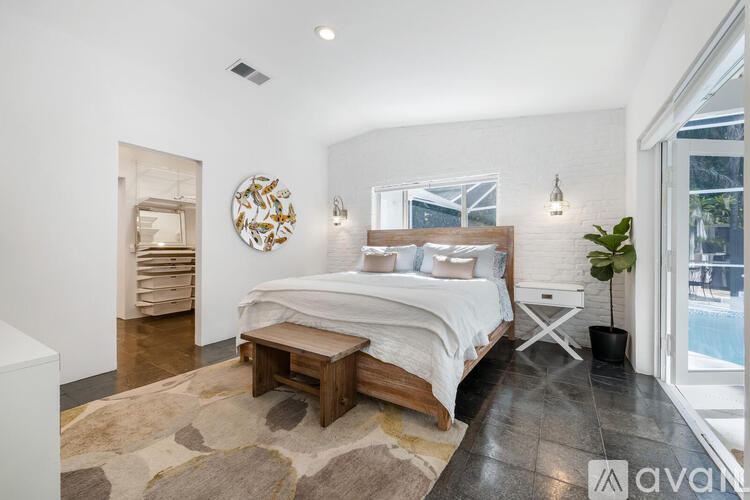 A bedroom with a large bed and a mirror on the wall.