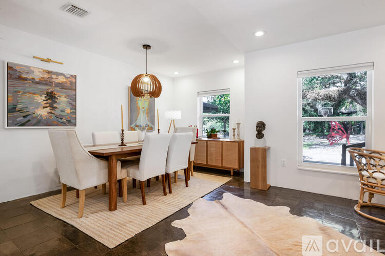 A dining room with a wooden table and chairs.