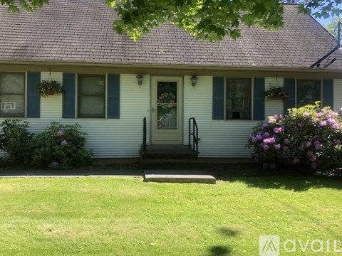 A house with a white front door and a black railing.
