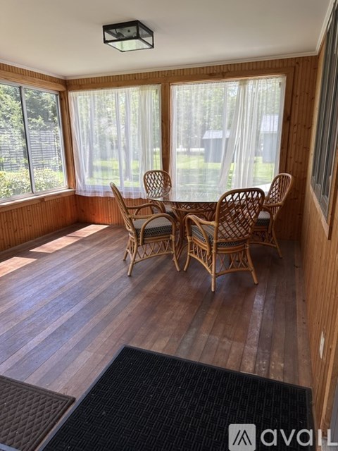 A room with wooden floors and a table with chairs.