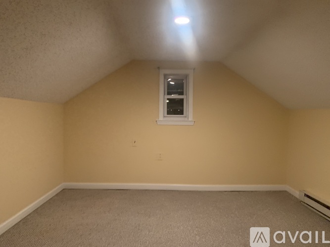A room with a window and carpeted floor.