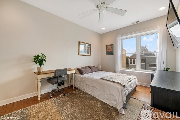 A bedroom with a bed, desk, and chair.