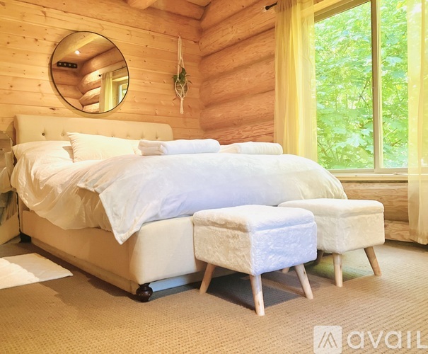A bedroom with a large bed and a round mirror on the wall.