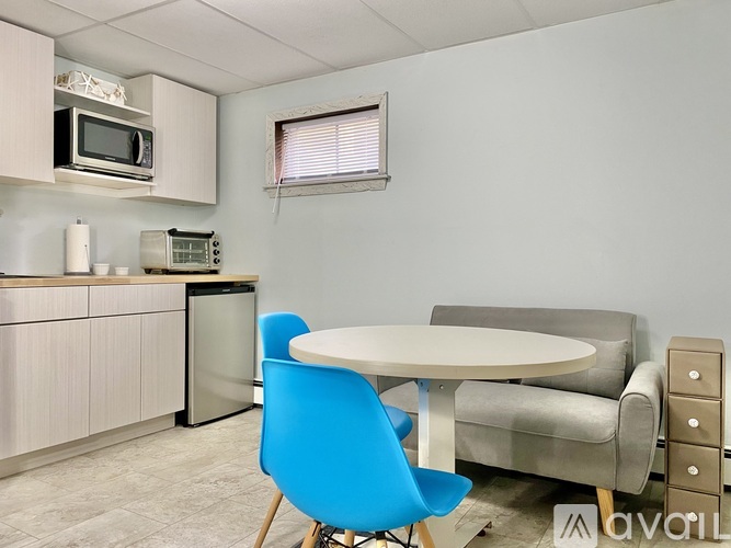 A kitchen with a table and chairs.