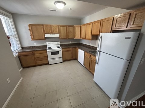 A kitchen with wooden cabinets and a white refrigerator.