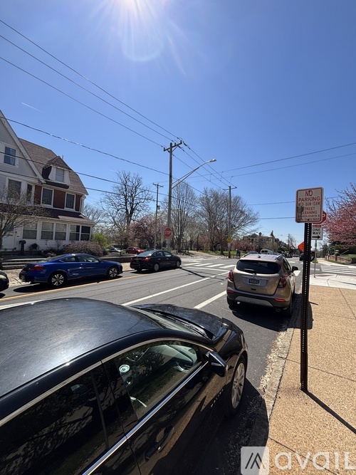 A car is parked on the side of the road with a sign in the background.