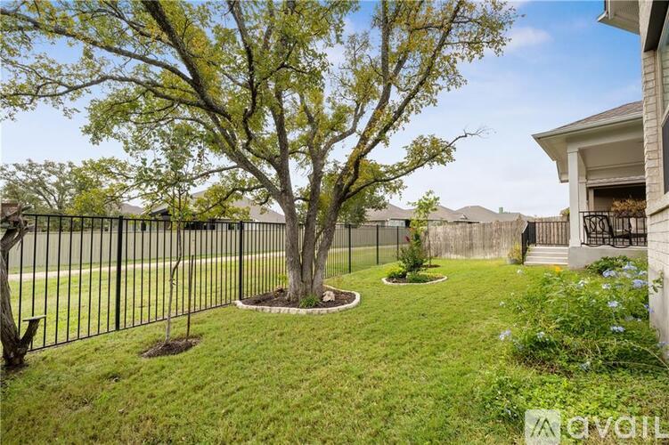 A tree in a yard with a house in the background.
