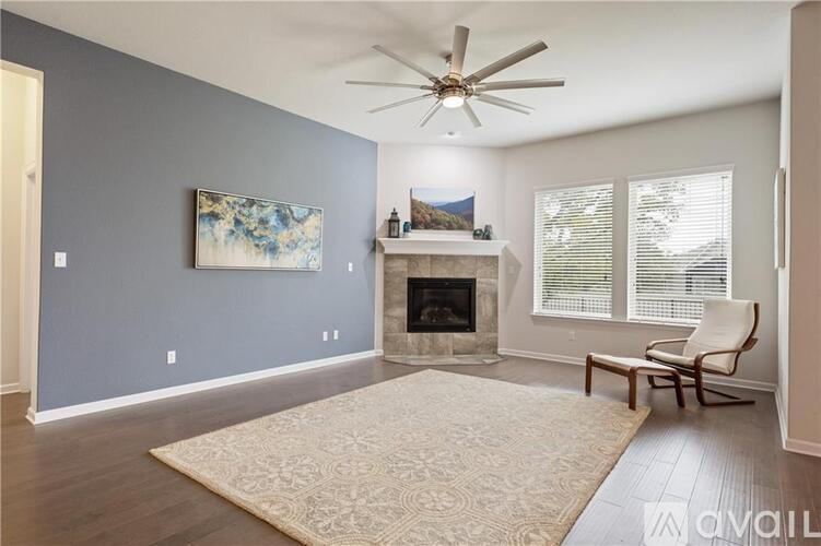 A living room with a fireplace and a painting on the wall.