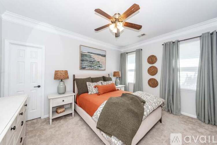 A bedroom with a large bed and a ceiling fan.