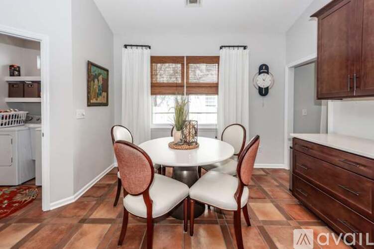 A dining room with a round table and chairs.