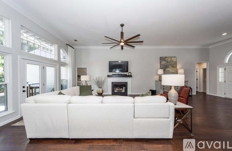 A living room with a white couch and a fireplace.