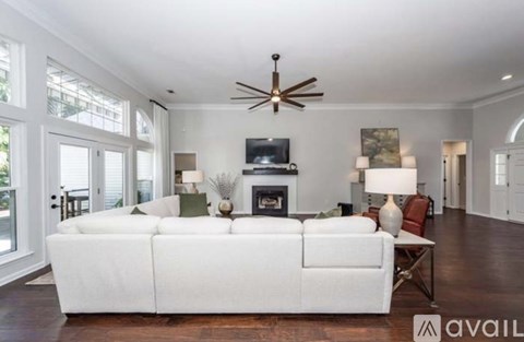 A living room with a white couch and a fireplace.