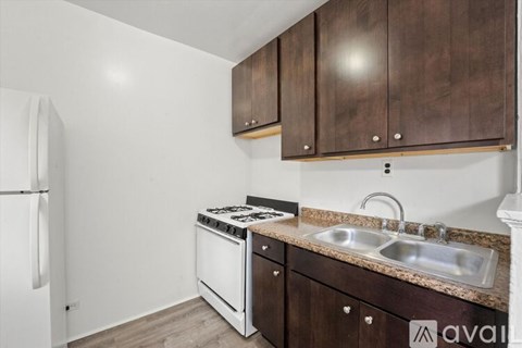 A kitchen with brown cabinets and a white fridge.