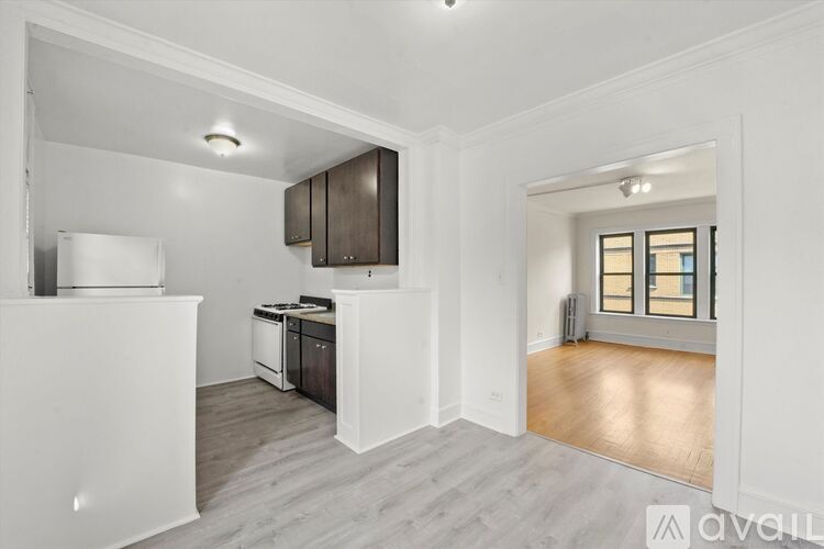 A kitchen with white appliances and wooden floors.