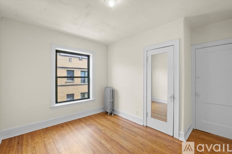 A room with a window, a door, and a radiator.