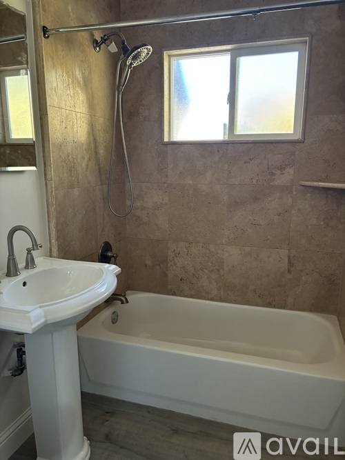 A bathroom with a white sink and bathtub.