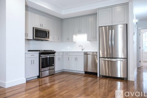 A kitchen with white cabinets and stainless steel appliances.